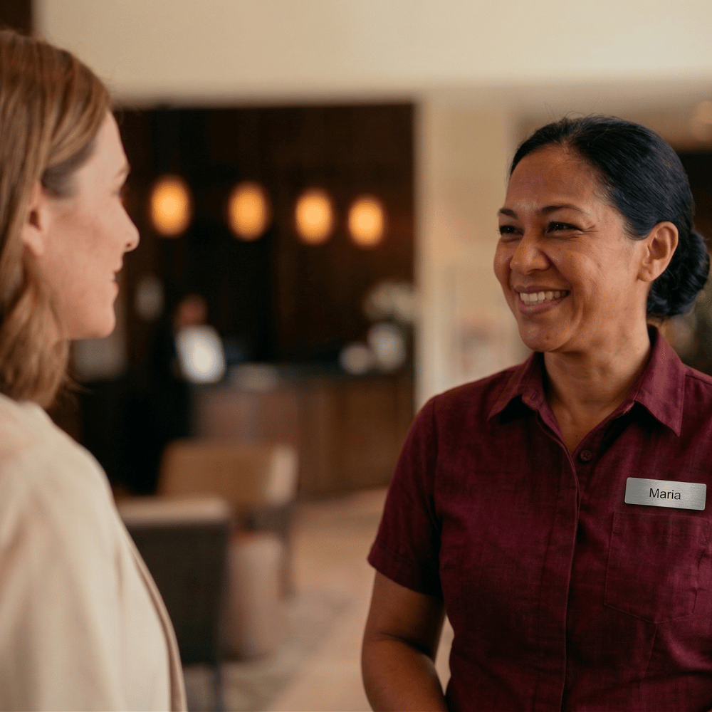 Club team member Maria smiling while welcoming a guest at reception